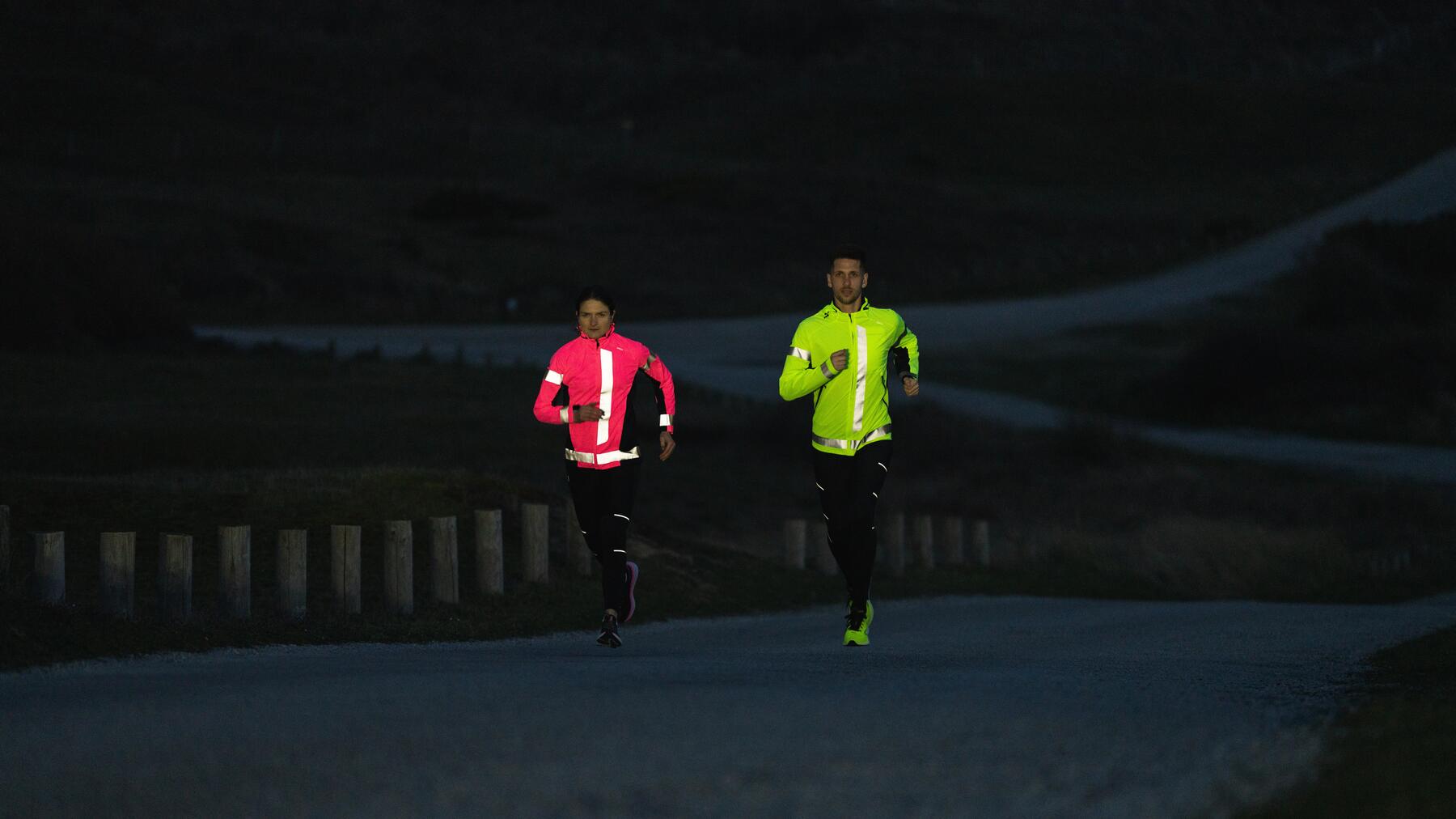 Para w odzieży sportowej z odblaskami biegająca wieczorową porą