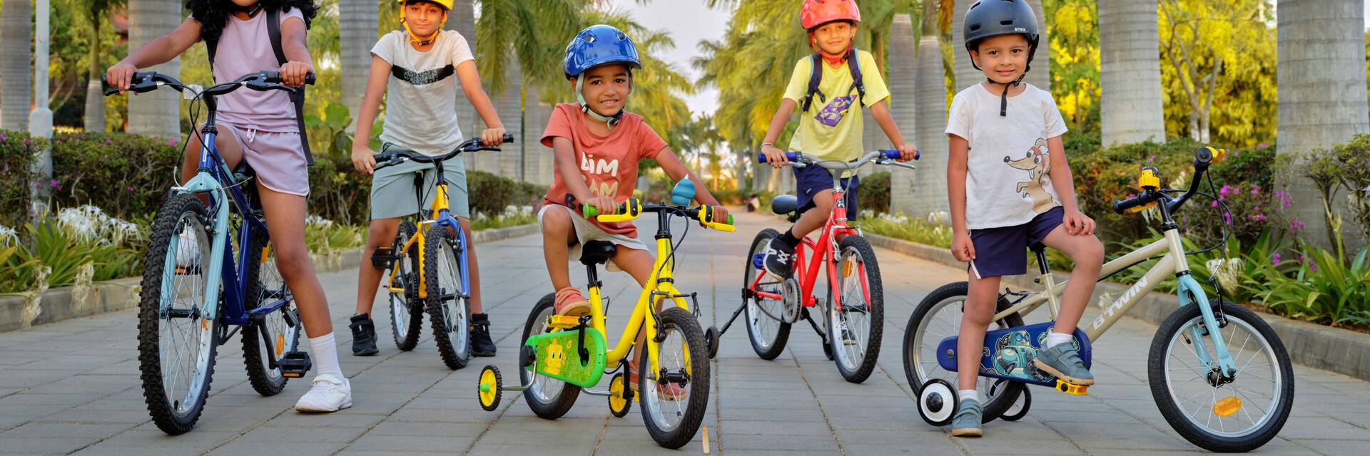 Grupa dzieci w kaskach rowerowych uprawiająca aktywność fizyczną jeżdżąc na rowerach