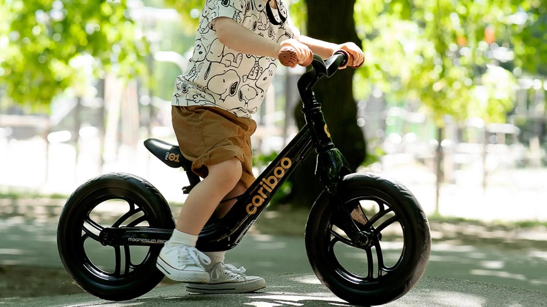 Chłopczyk w kasku na rowerku biegowym