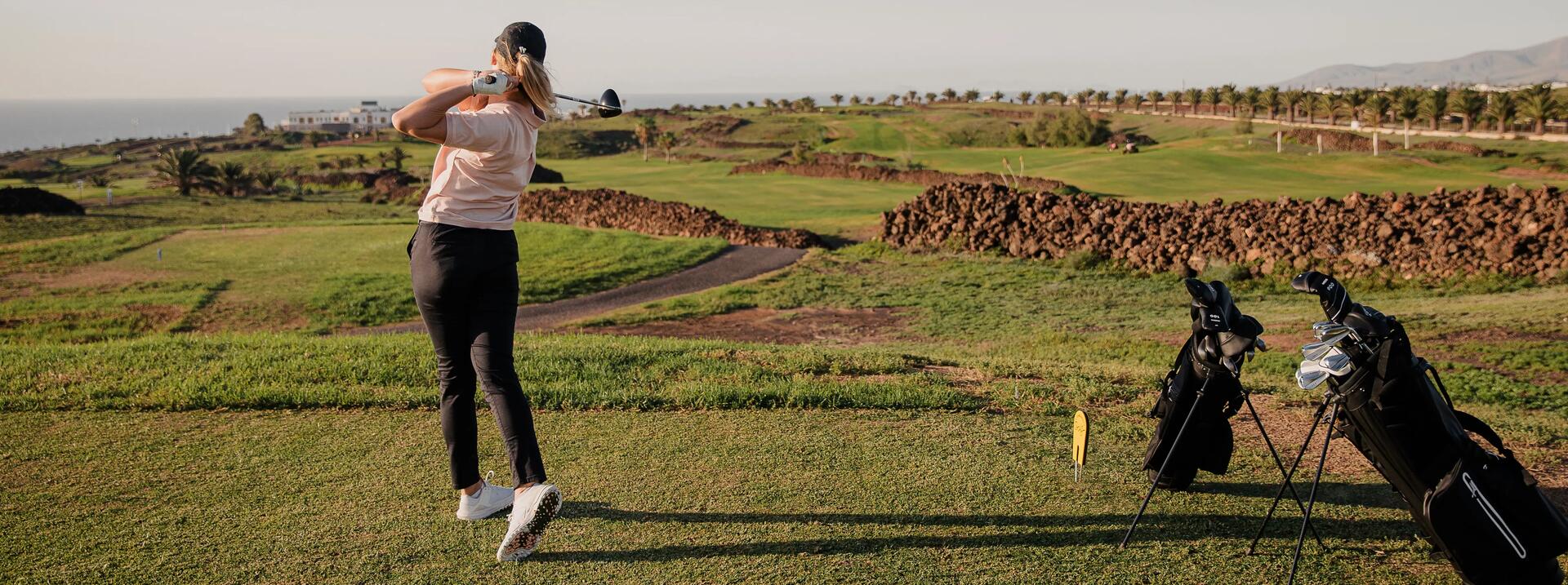 mujer golpeando con madera de salida golf