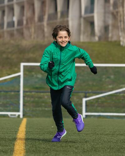 Chlapec hrajúci futbal v nepremokavom oblečení
