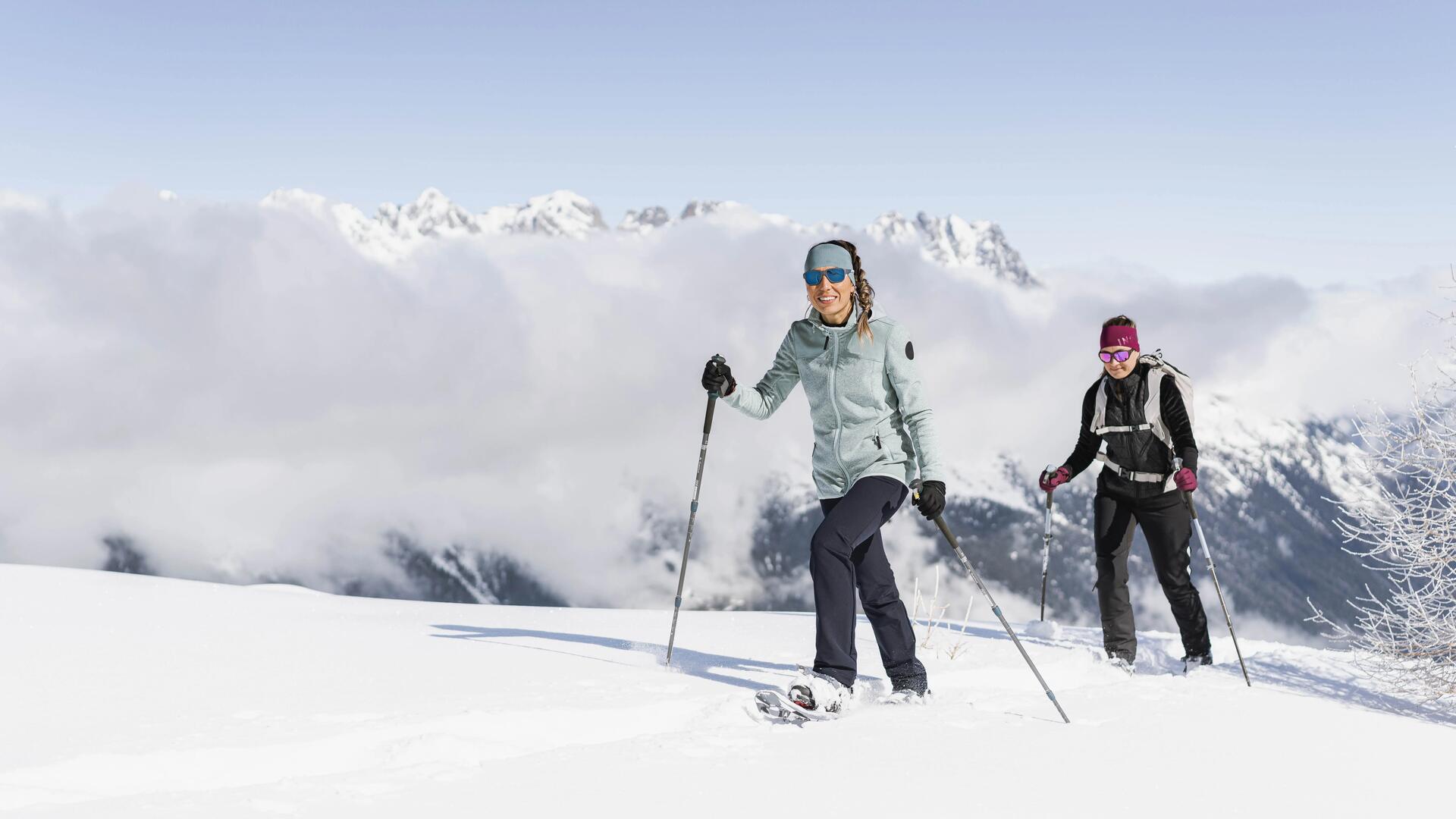 Groupe d'amis qui monte une montagne en raquette à neige