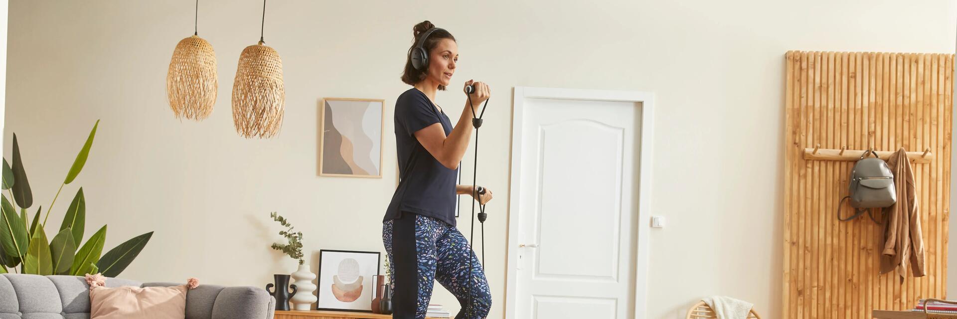 Frau macht tägliches Cardio-Training auf dem Stepper zuhause