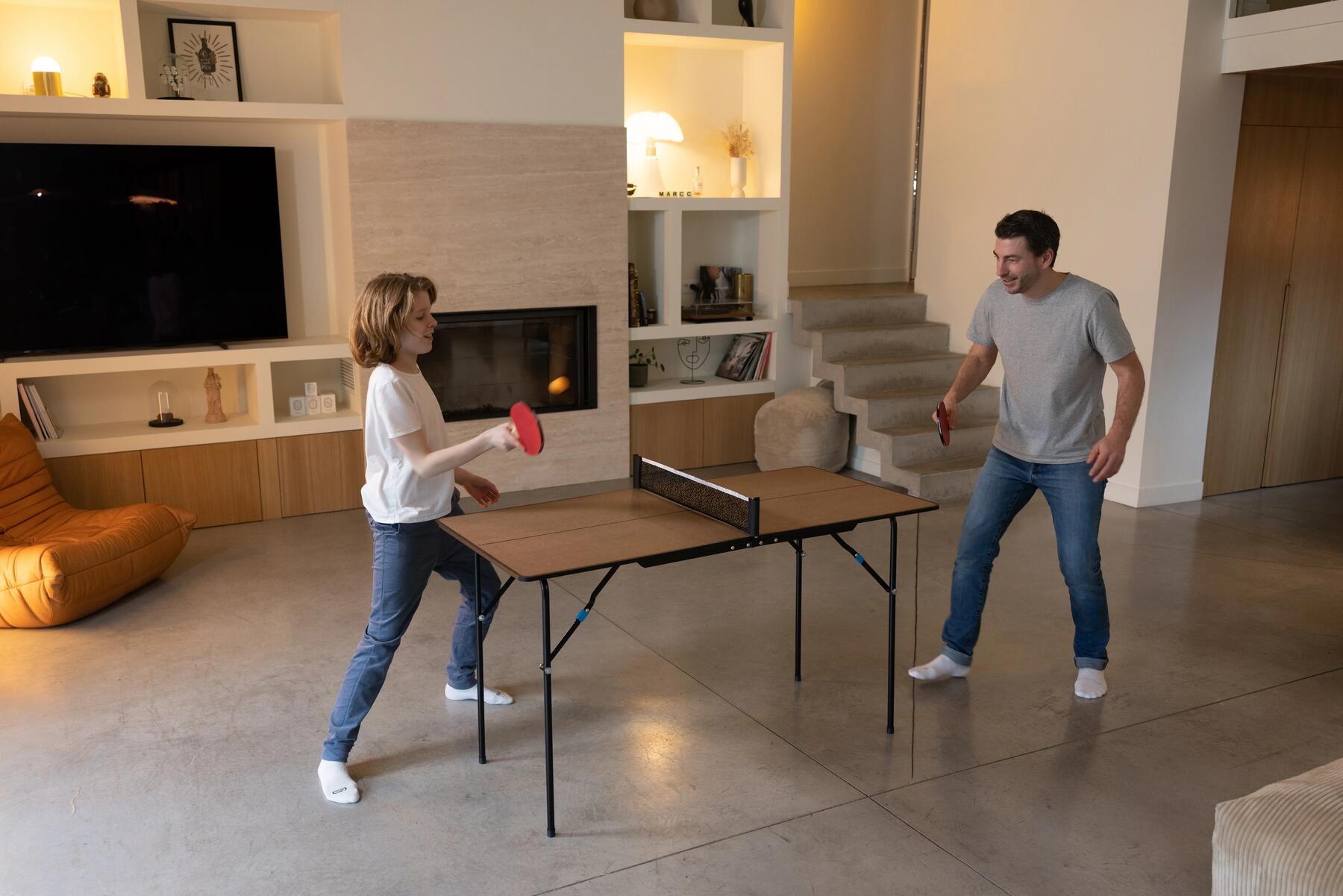 Vater und Sohn spielen an einer Indoor-Tischtennisplatte