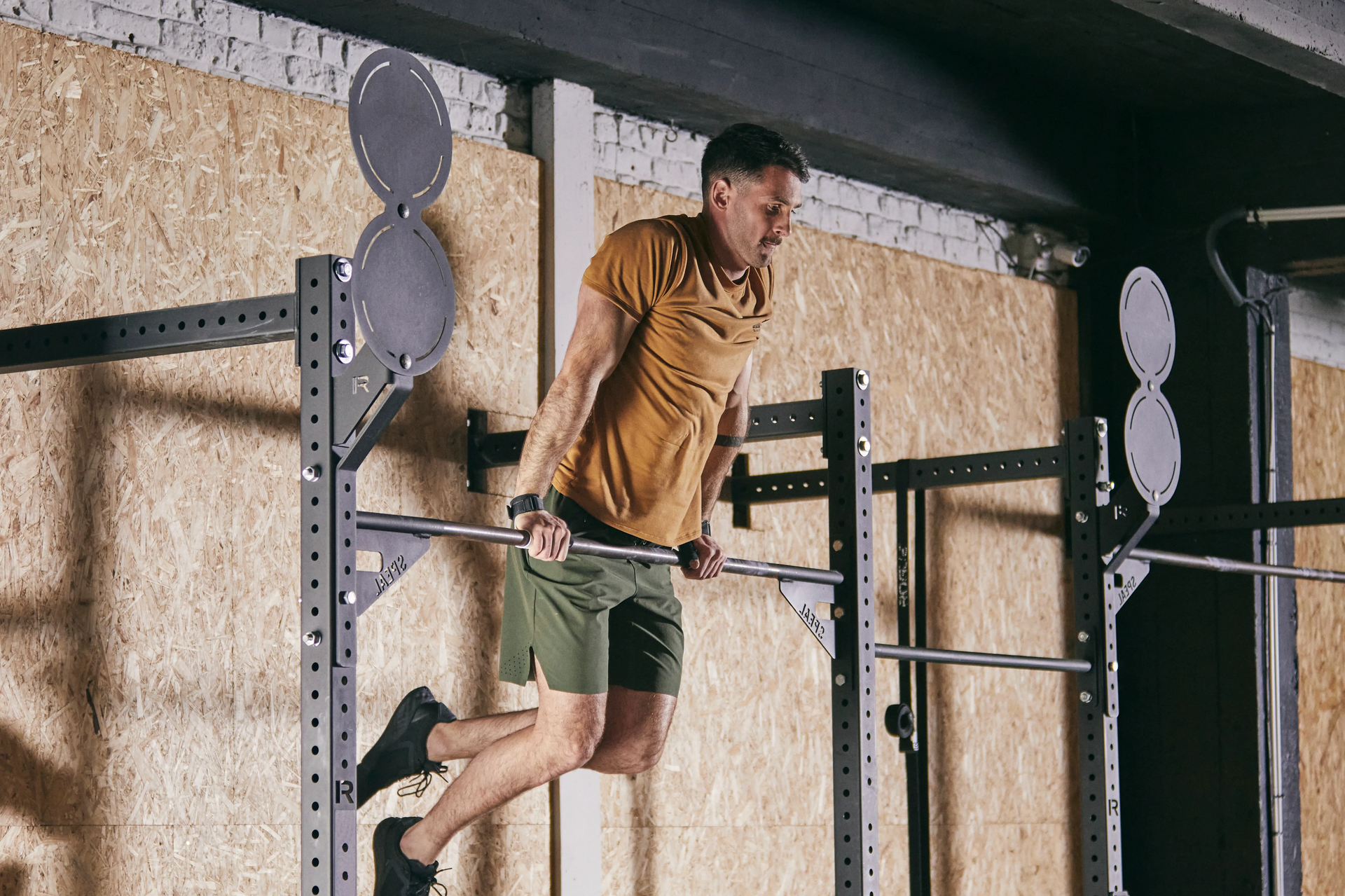 Mężczyzna trenujący na drążku do podciągania muscle up