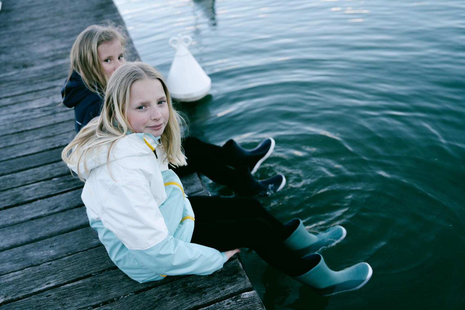 Niñas sentadas disfrutando del lago