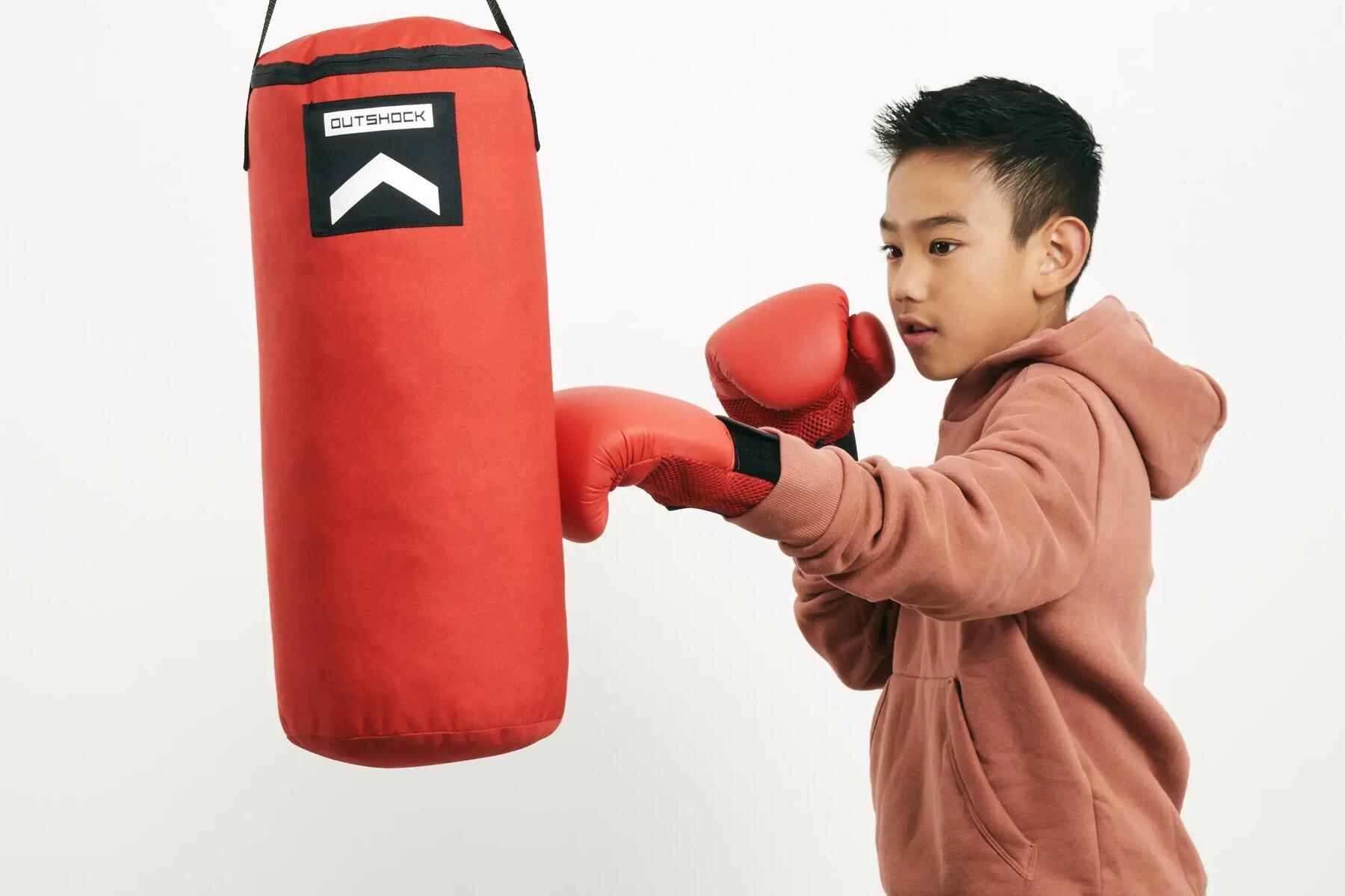 chłopiec w odzieży sportowej podczas treningu z workiem  bokserskim