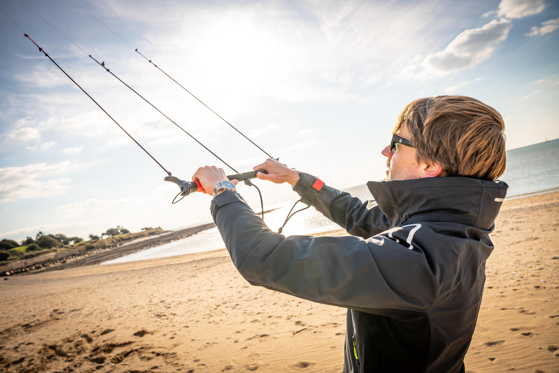 Mężczyzna trzymający latawiec do kitesurfingu w okularach przeciwsłonecznych
