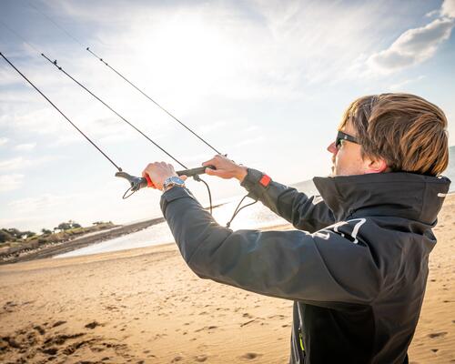 Mężczyzna trzymający latawiec do kitesurfingu w okularach przeciwsłonecznych