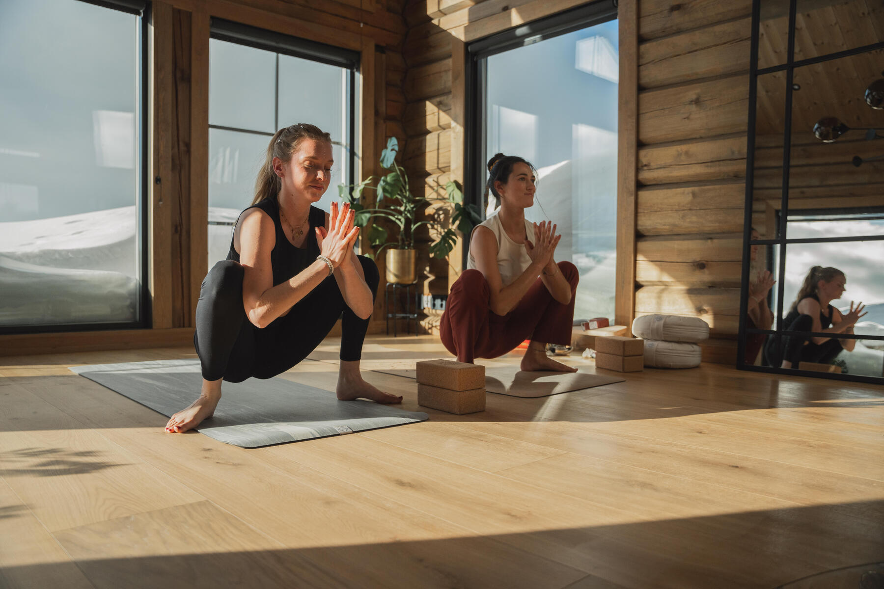 Kobiety w strojach fitness ćwiczące pozycję Malasana w jodze