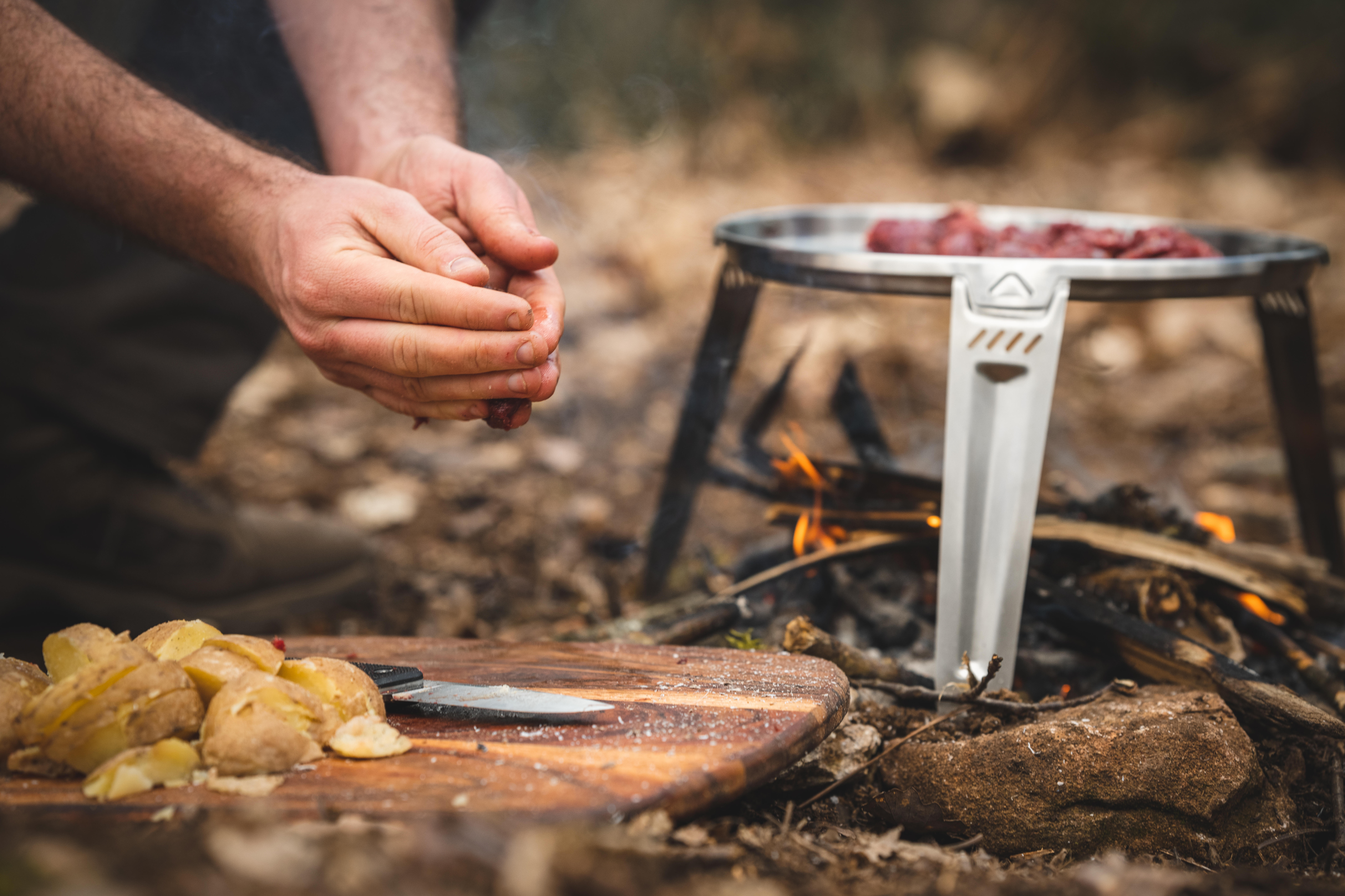 Camping cookware used over an open campfire during outdoor cooking