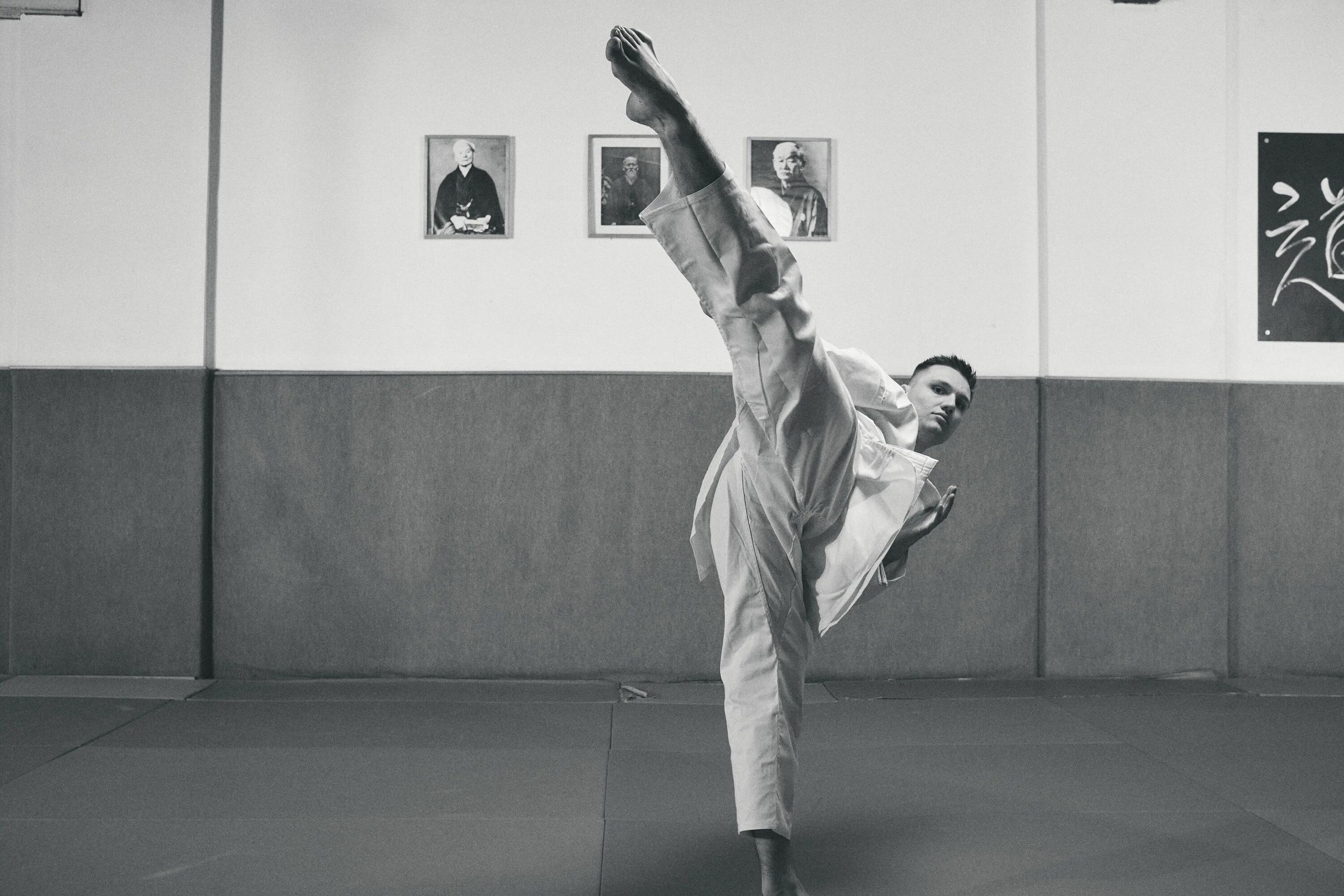 mężczyzna ubrany w dobok wykonujący kopnięcie taekwondo