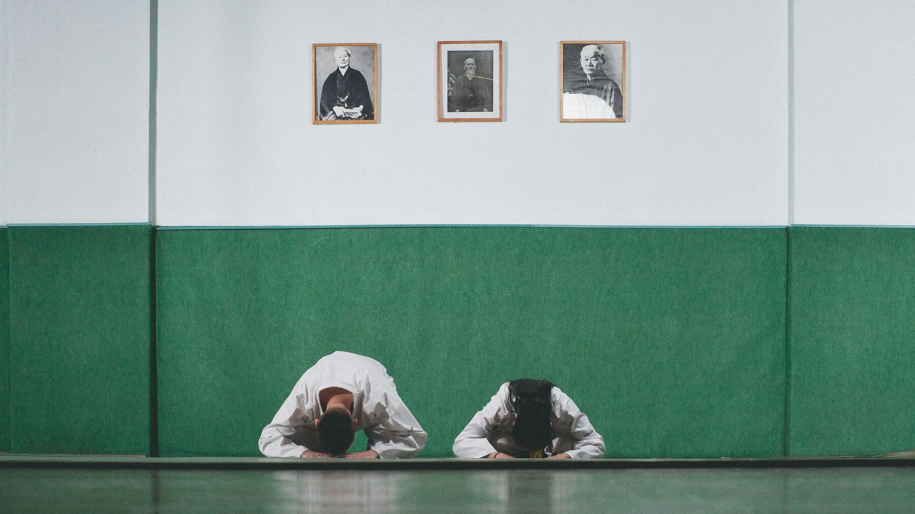 Mann und Frau verbeugen sich respektvoll auf der Karate-Matte