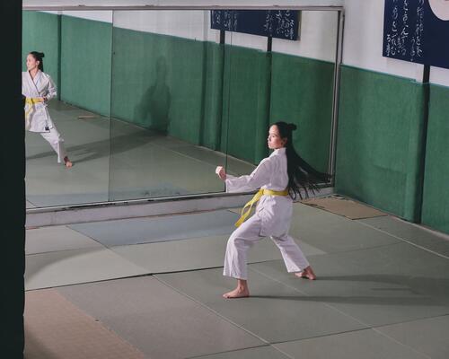 Kobieta szlifująca techniki Shaolin kung fu na sali przed lustrami