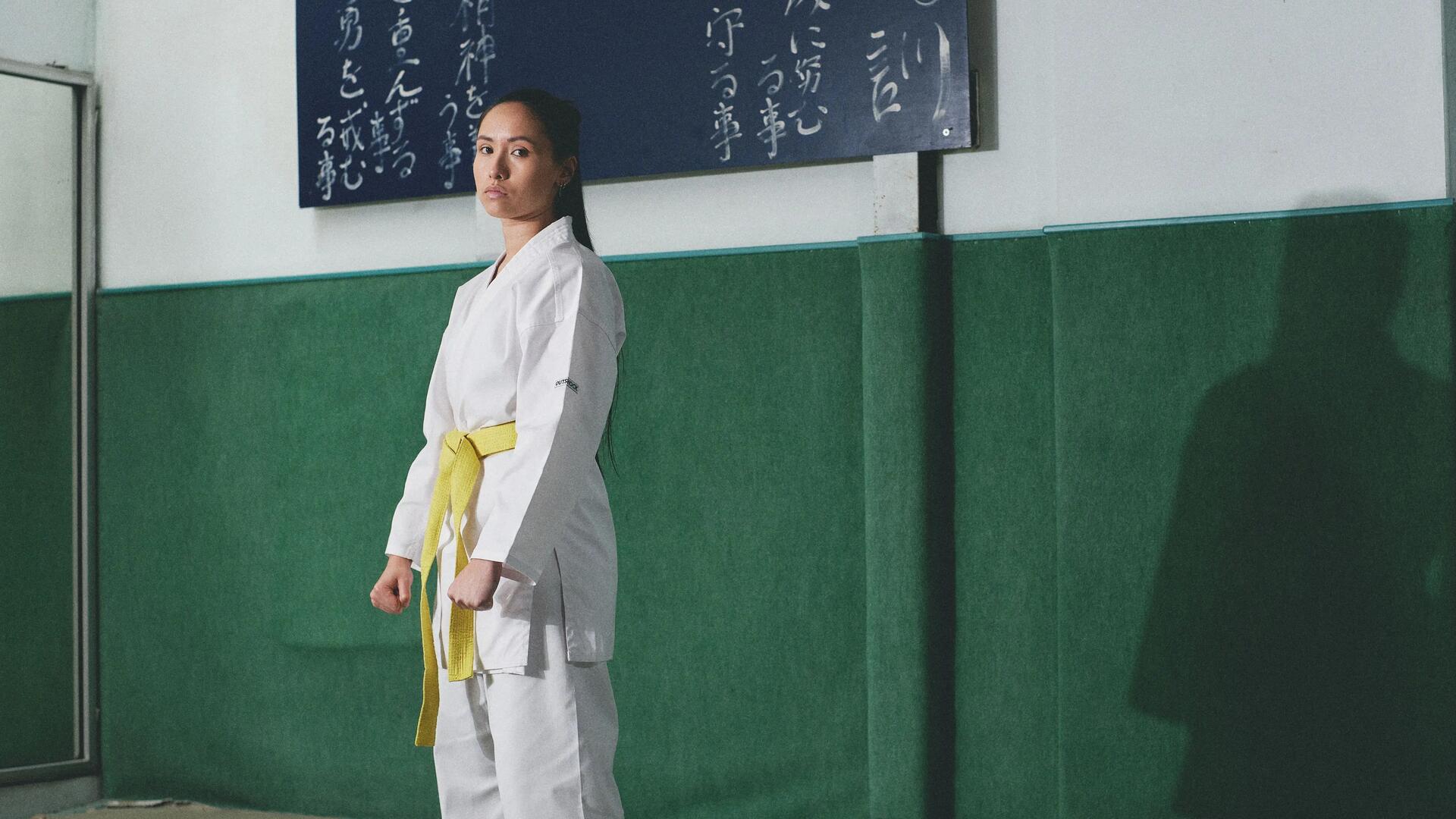 kobieta ubrana w kimono z żółtym pasem do karate