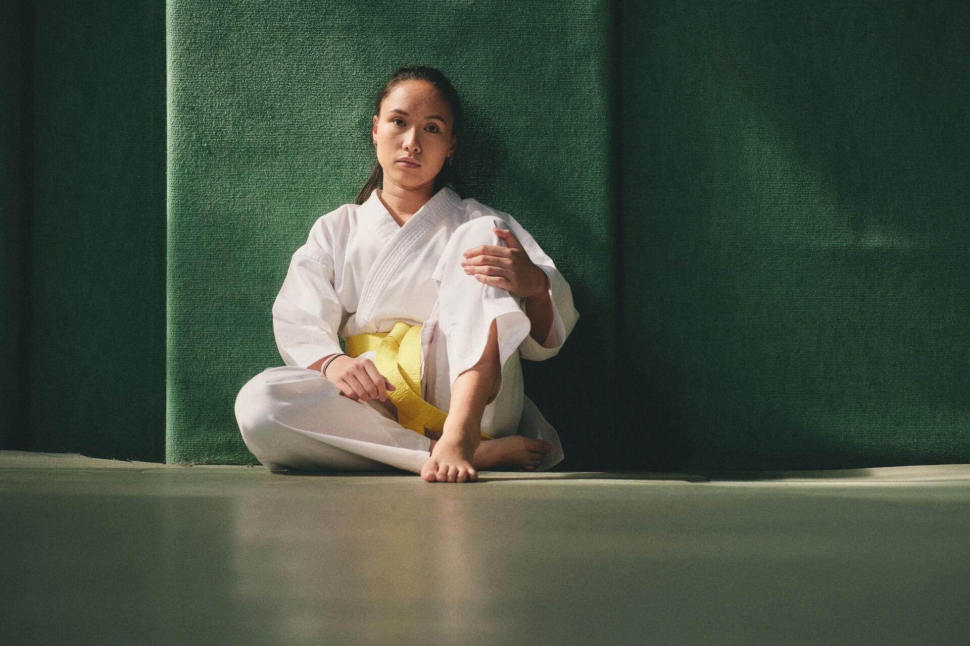 Kobieta siedząca z żółtym pasem karate