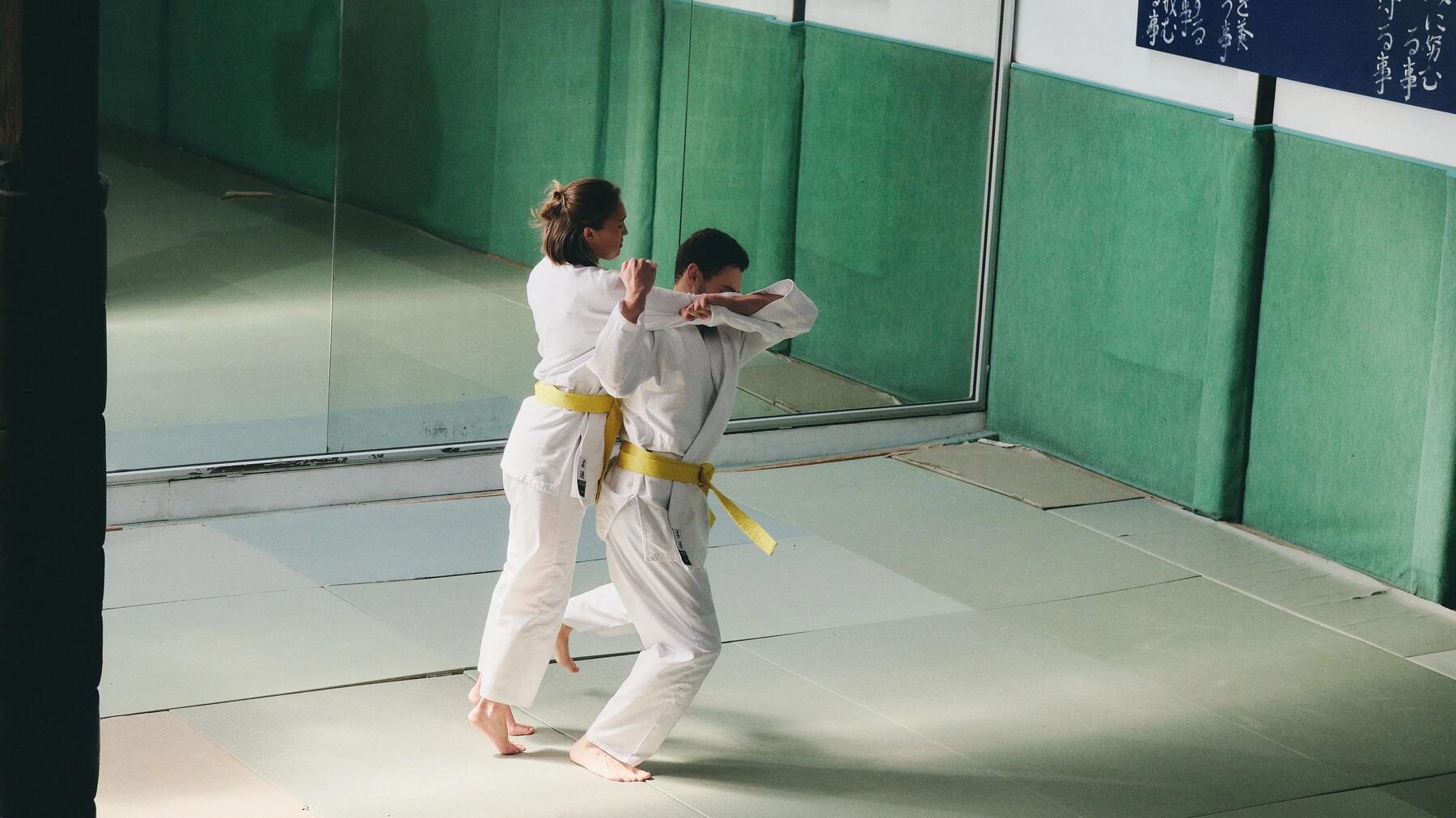Ein Judo-Wettkampf zwischen einer Frau und einem Mann in einer Sporthalle