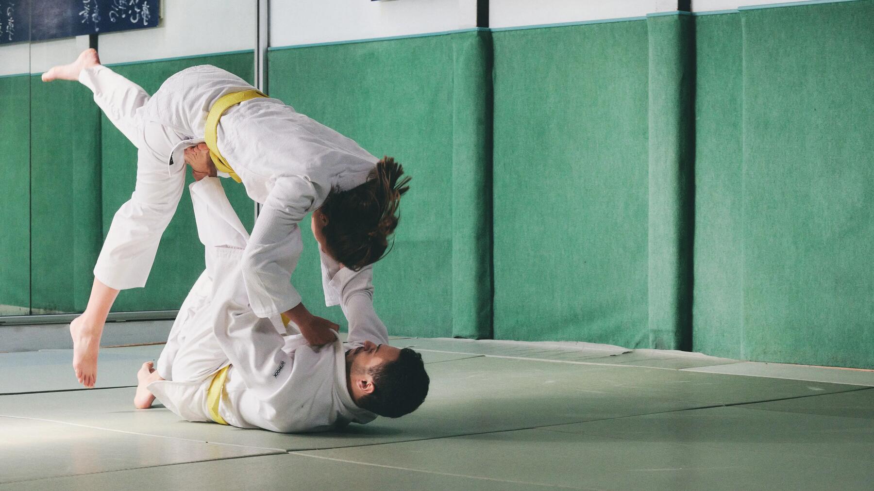 Anwendung einer Nage-Waza (Wurftechnik) während eines Judo-Kampfes zwischen einer Frau und einem Mann