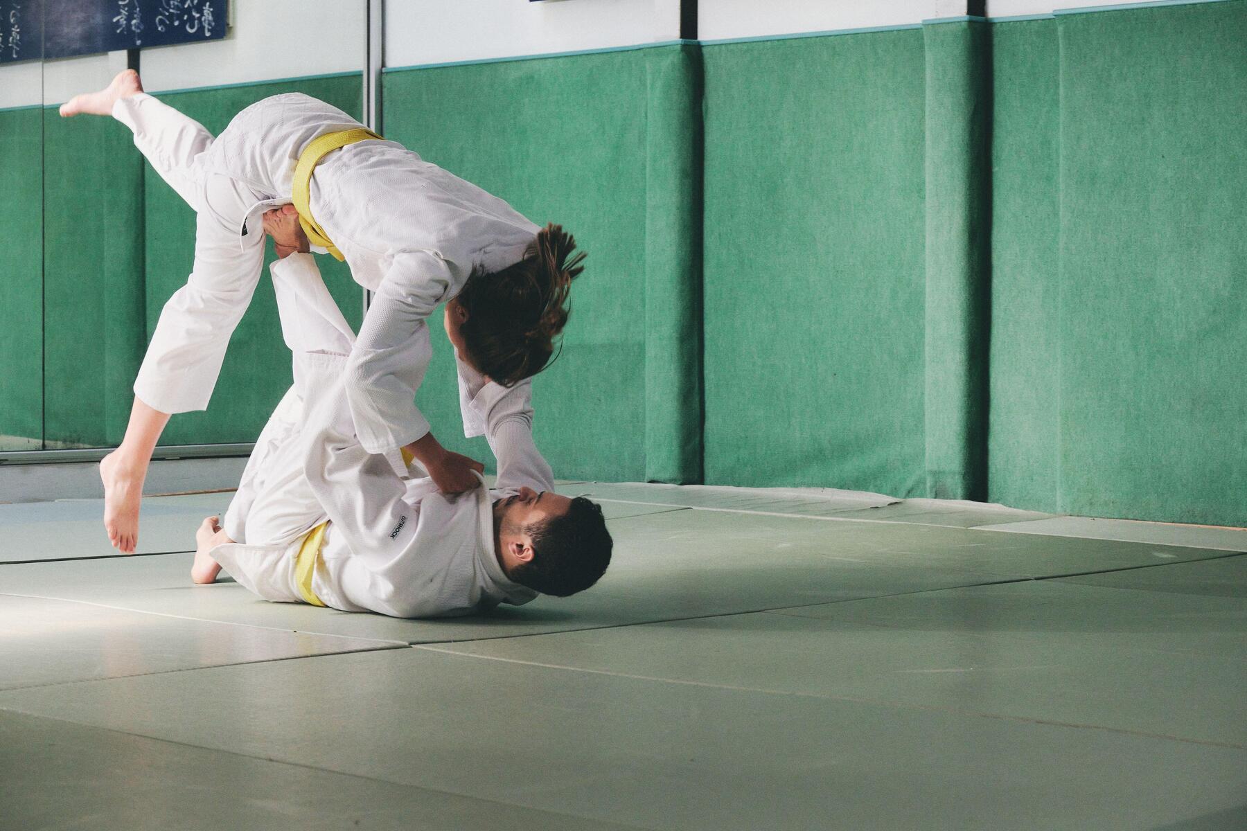 Kobieta i mężczyzna trenujący judo na sali treningowej przed Igrzyskami Olimpijskimi