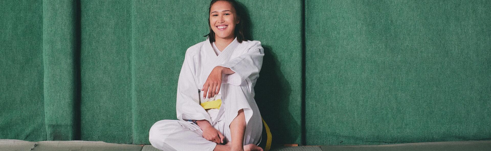 kobieta siedząca po ścianą w kimonie do trenowania sztuki walki