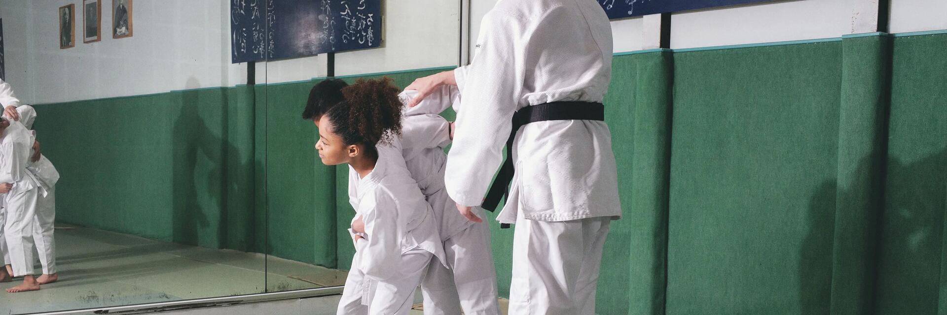 Ein Kampfrichter trennt zwei Kinder während eines Judo-Wettkampfs