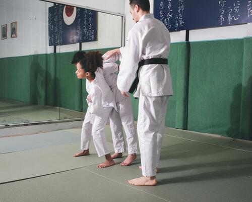 Ein Kampfrichter trennt zwei Kinder während eines Judo-Wettkampfs