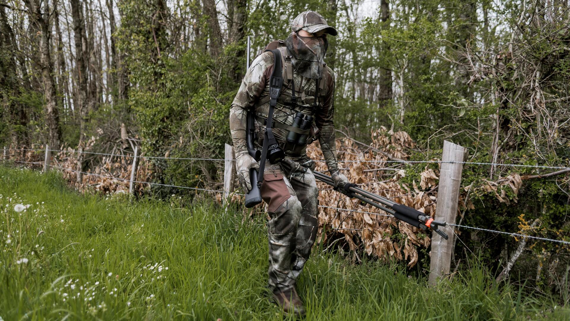 Un chasseur à l'approche qui longe une haie 