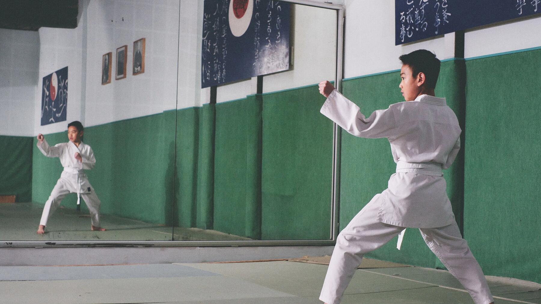 Kind beim Karate-Training in Kampfkunst-Pose