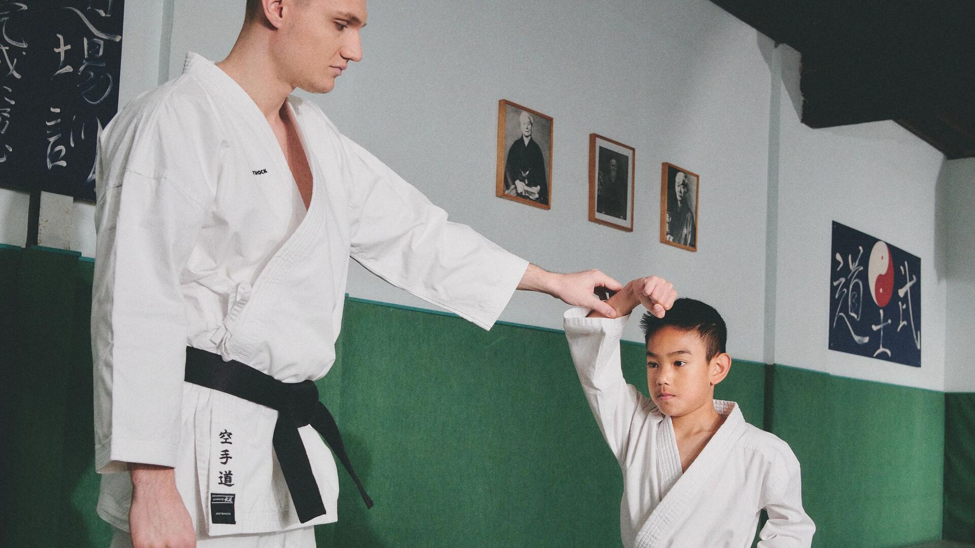 mężczyzna i chłopiec ubrani w doboki  trenujący  taekwondo