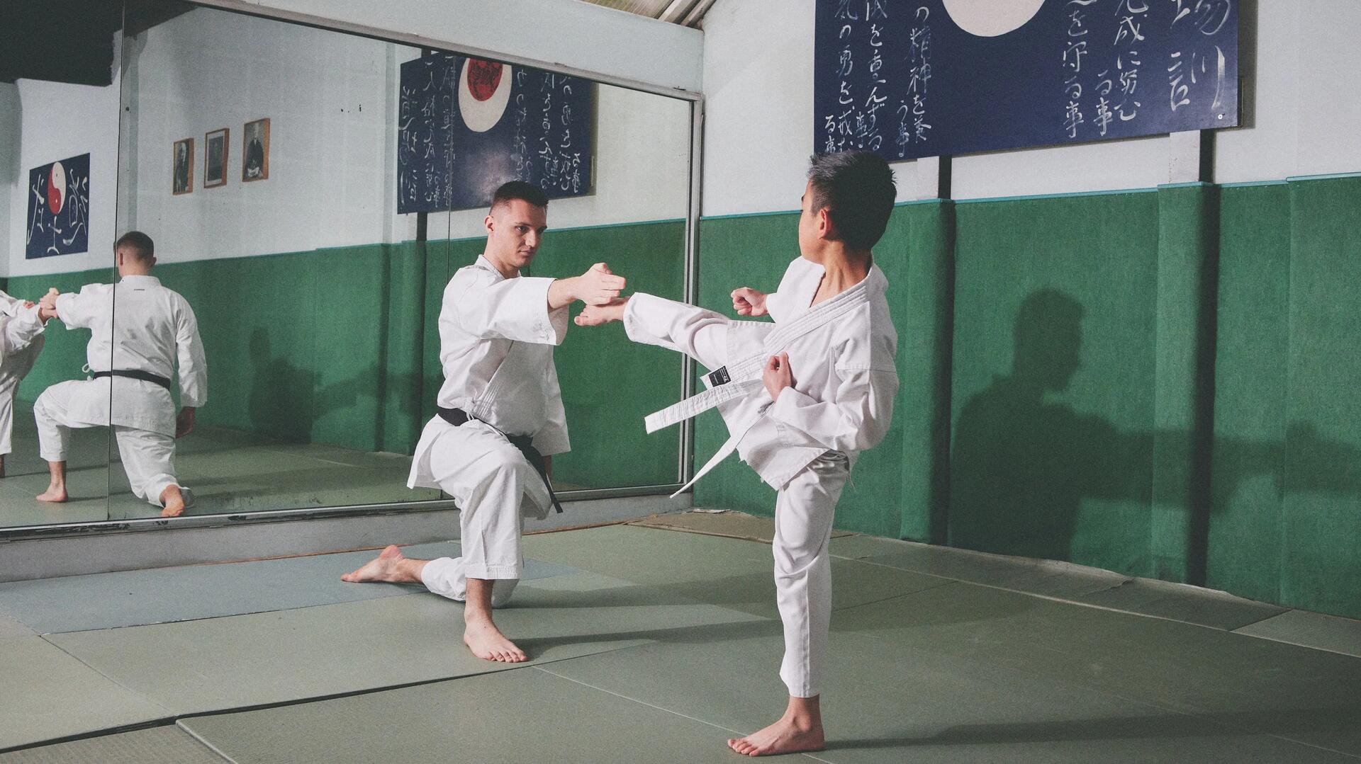 Chłopiec trenujący z trenerem kung fu na sali