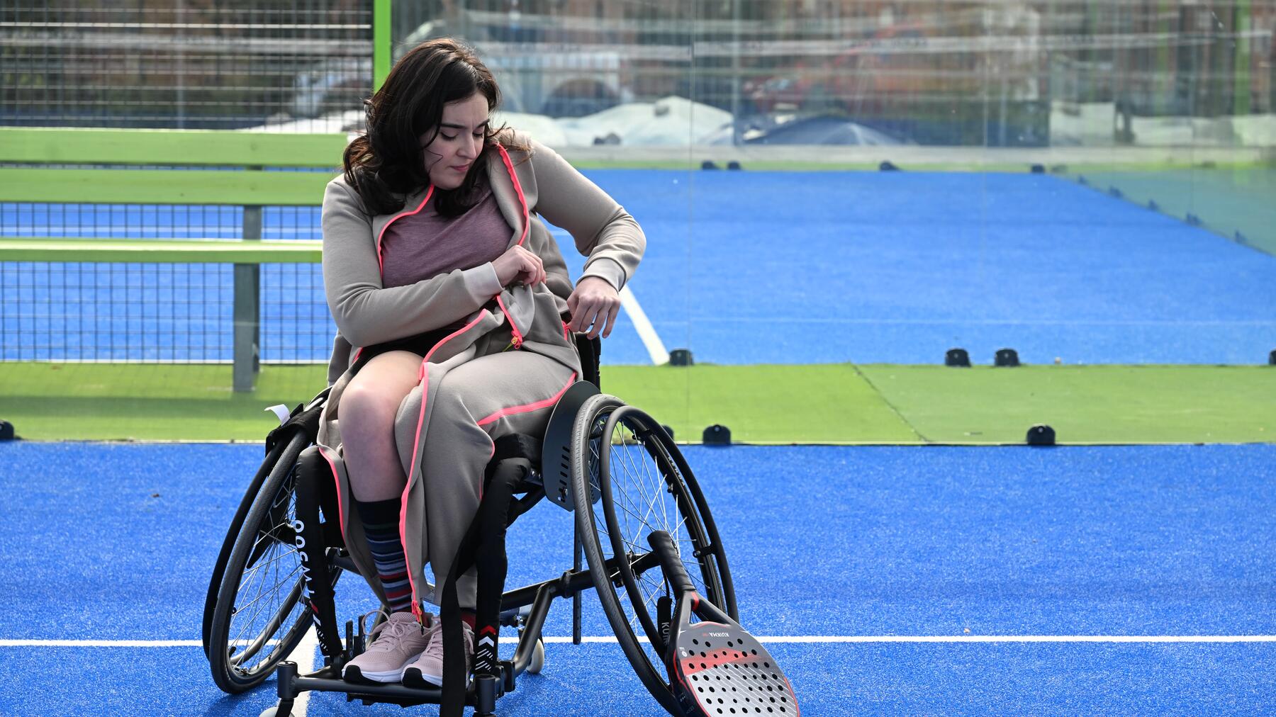 Eine sportliche Person im Rollstuhl beim dynamischen Padel spielen