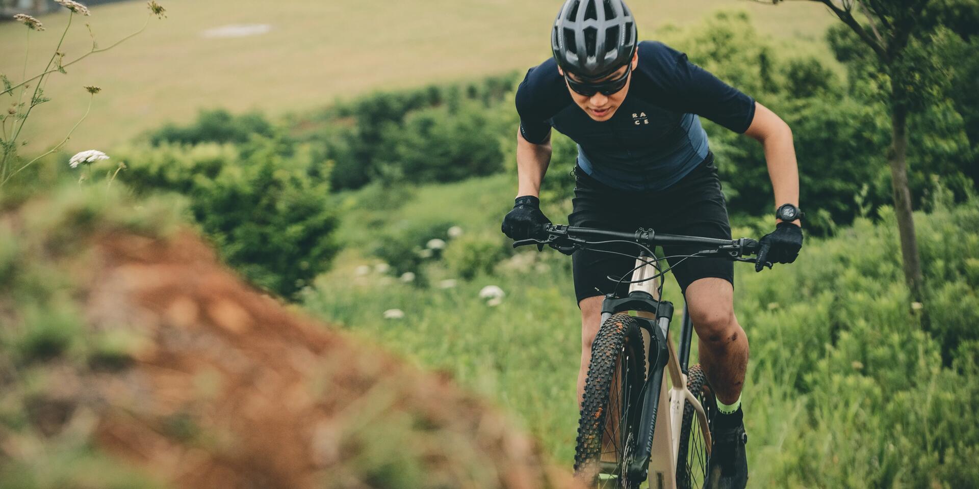 mężczyzna jadący na rowerze górskim z zegarkiem sportowym na ręce
