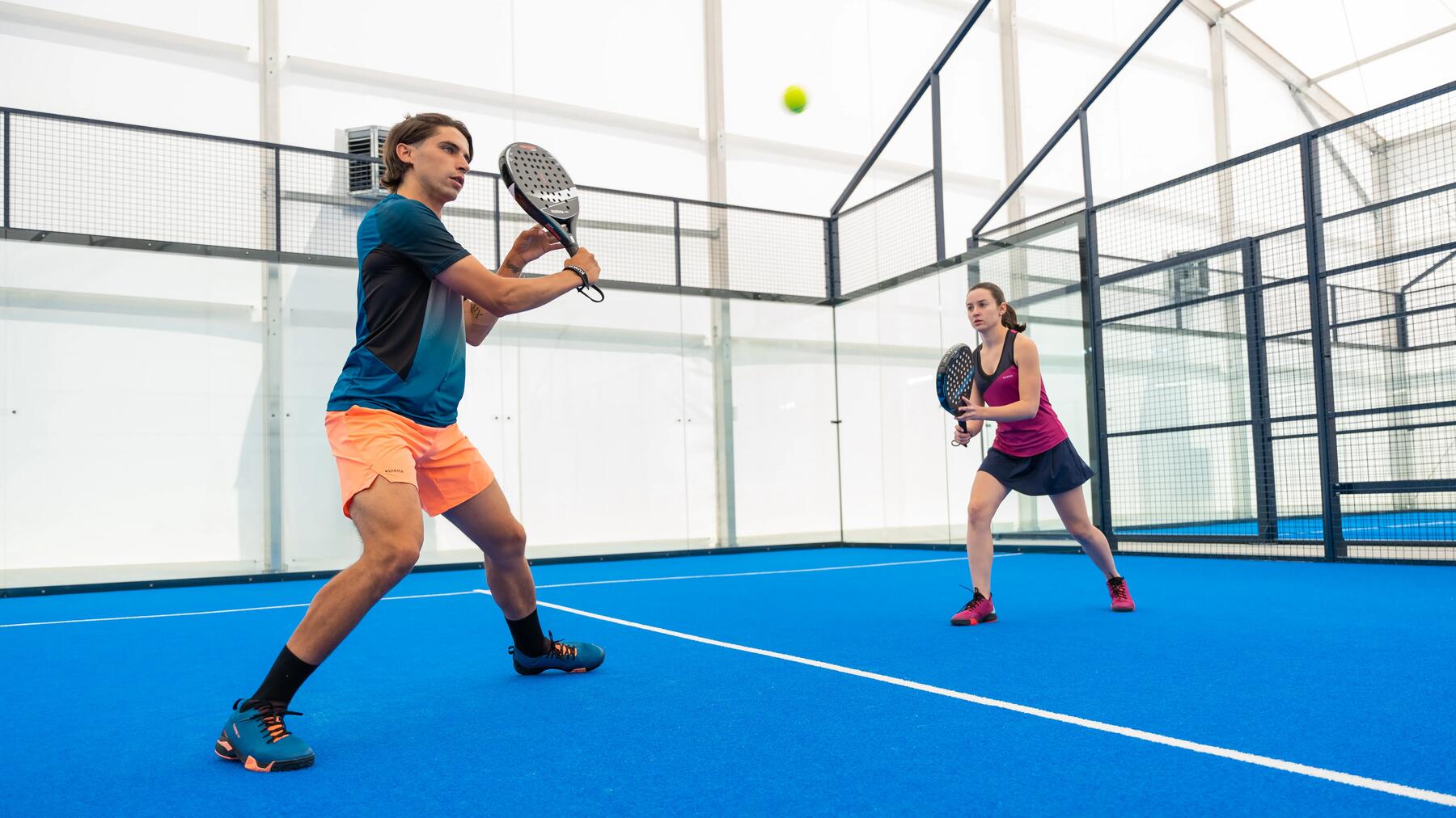 Zwei Padelspieler spielen sich während eines Doppel-Matches den Ball auf dem Court zu