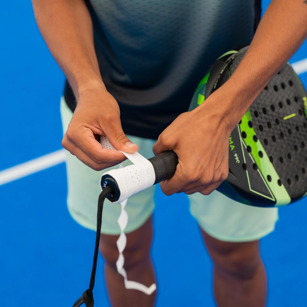 Eine Person wickelt ein Griffband um den Griff eines Padelschlägers.