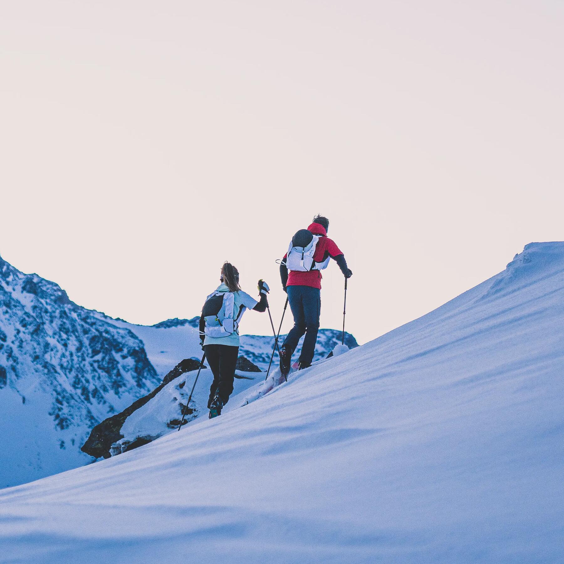 a man and a woman doing Decathlon ski touring in high mountain sunrise Wedze pacer outfit