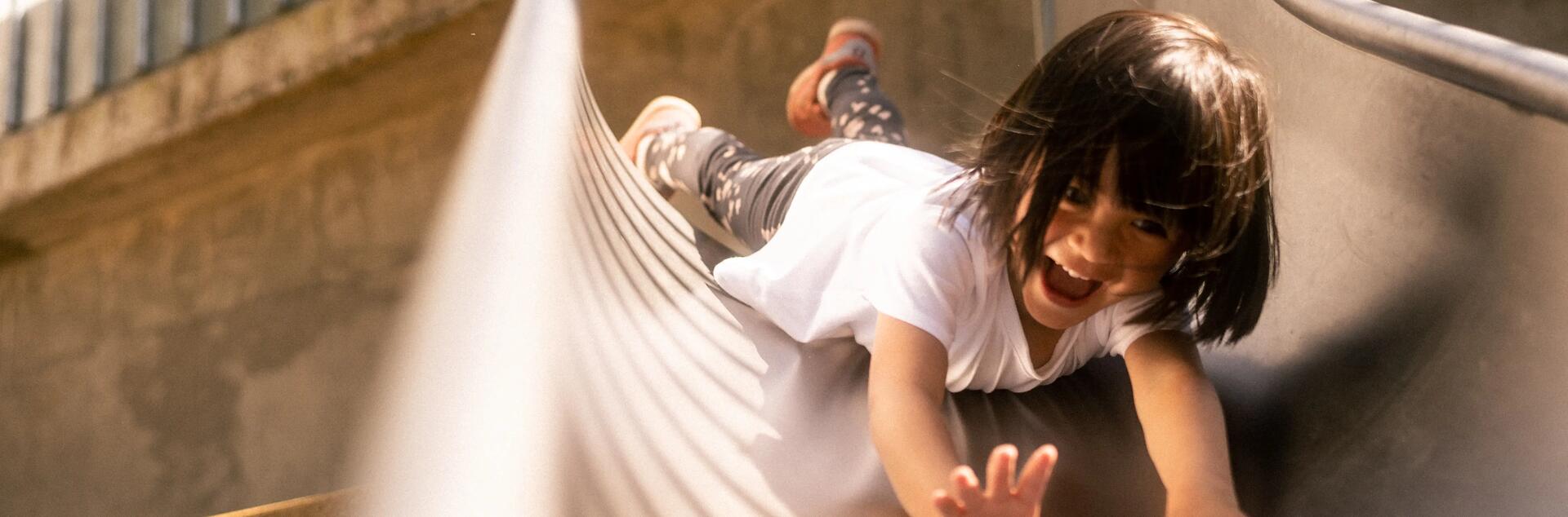 a little girl on a playground slide