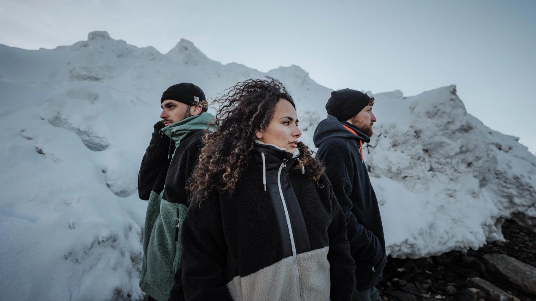 image d'ambiance : 3 personnes en polaire en haut d'une montagne avec des montagnes enneigées en arrière-plan