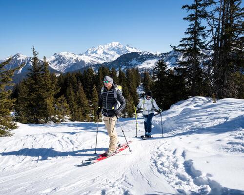 Ludzie wędrujący po górach w nartach kijkach i butach skiturowych