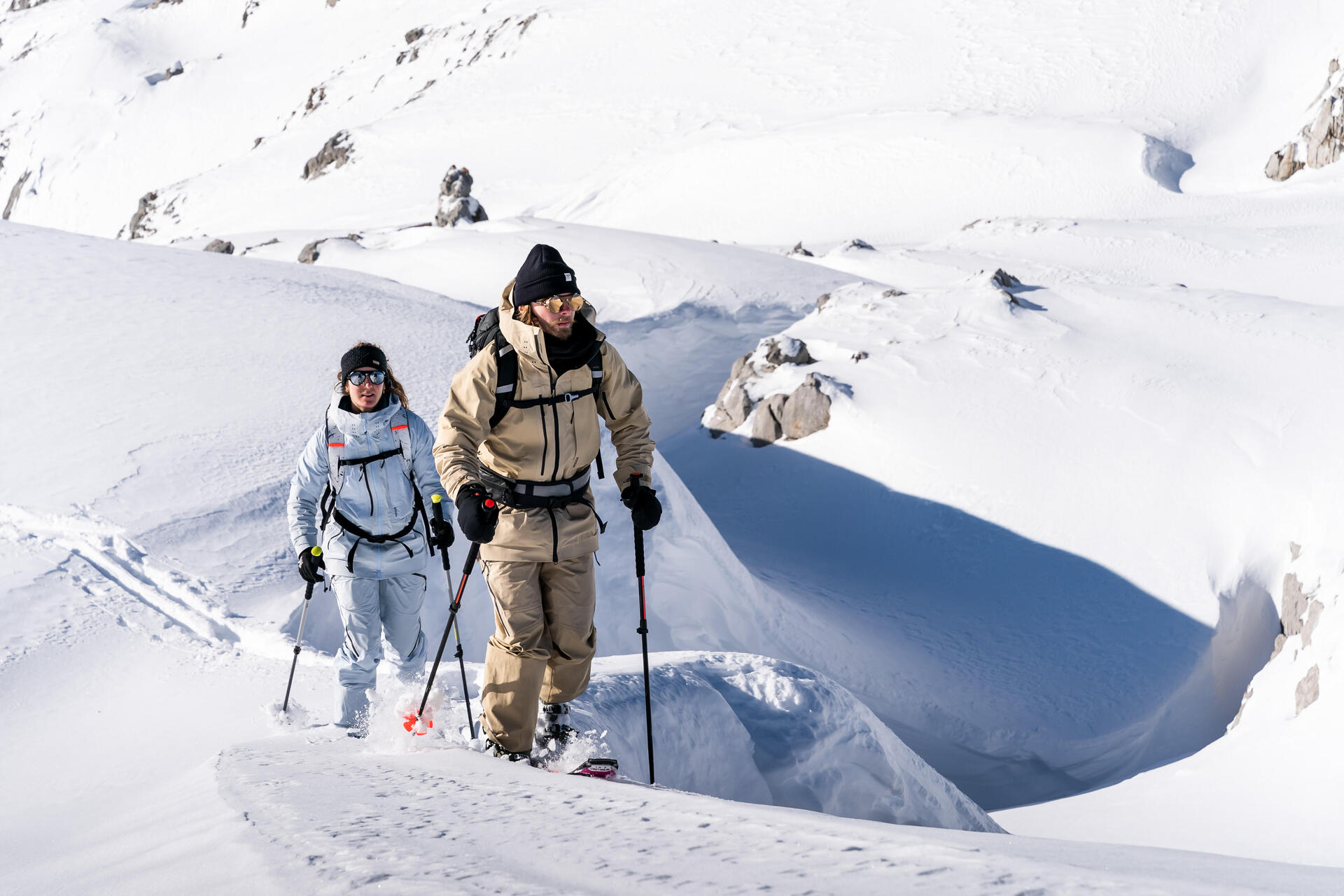 Para w odzieży zimowej z plecakami uprawiająca skitouring