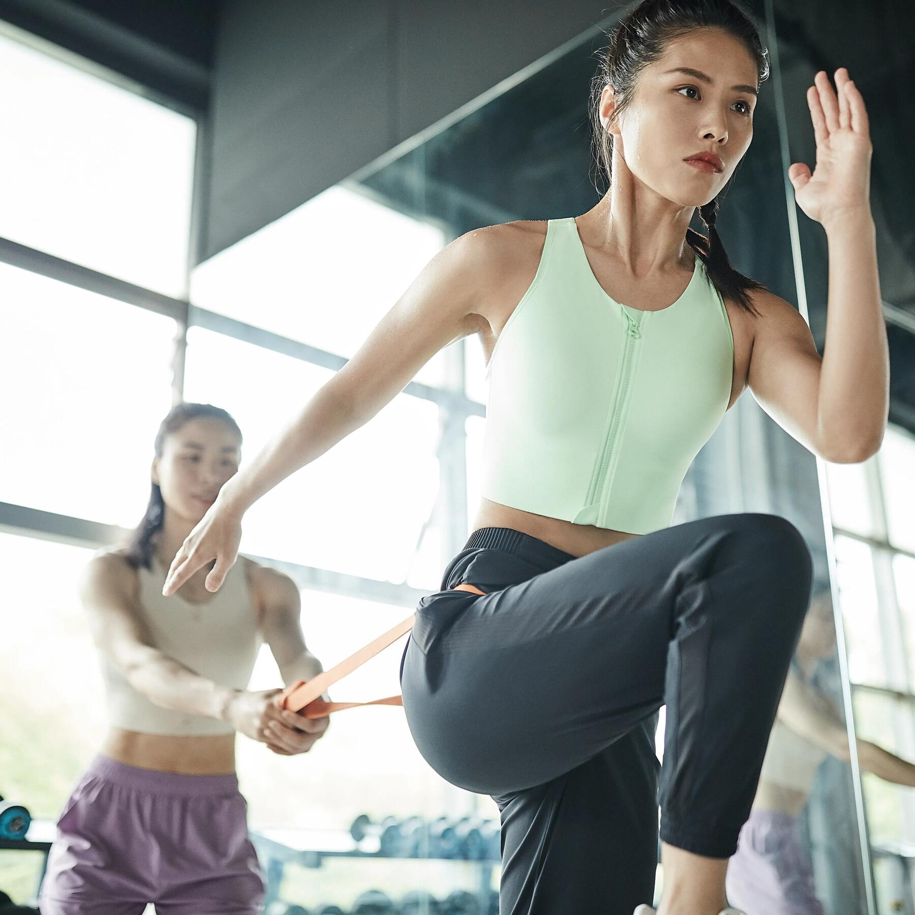 Kobieta w stroju sportowym poprawiająca swoją wydolność podczas treningu z gumą oporową po suplementacji cytruliny