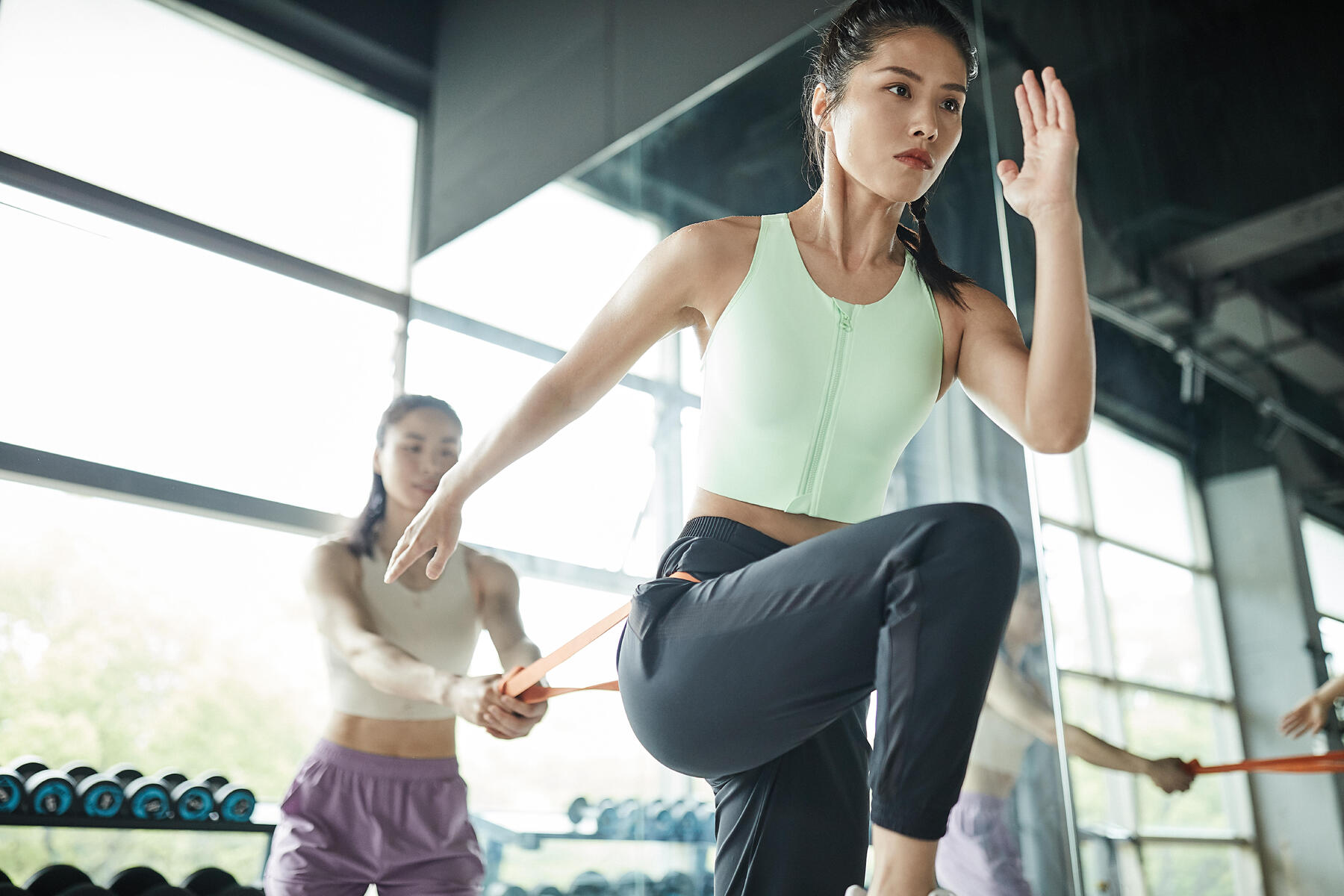 Kobieta w stroju sportowym trenująca z gumą oporową po suplementacji bcaa