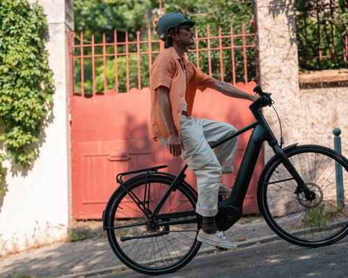 Mężczyzna w kasku rowerowym stosujący odpowiednią technikę jadąc na rowerze elektrycznym
