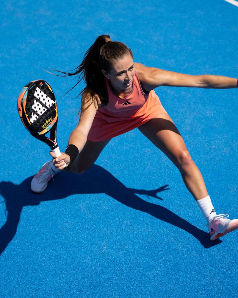 Eine Padel-Spielerin auf dem Court hält ihren Schläger bereit, um den Ball zu schlagenart