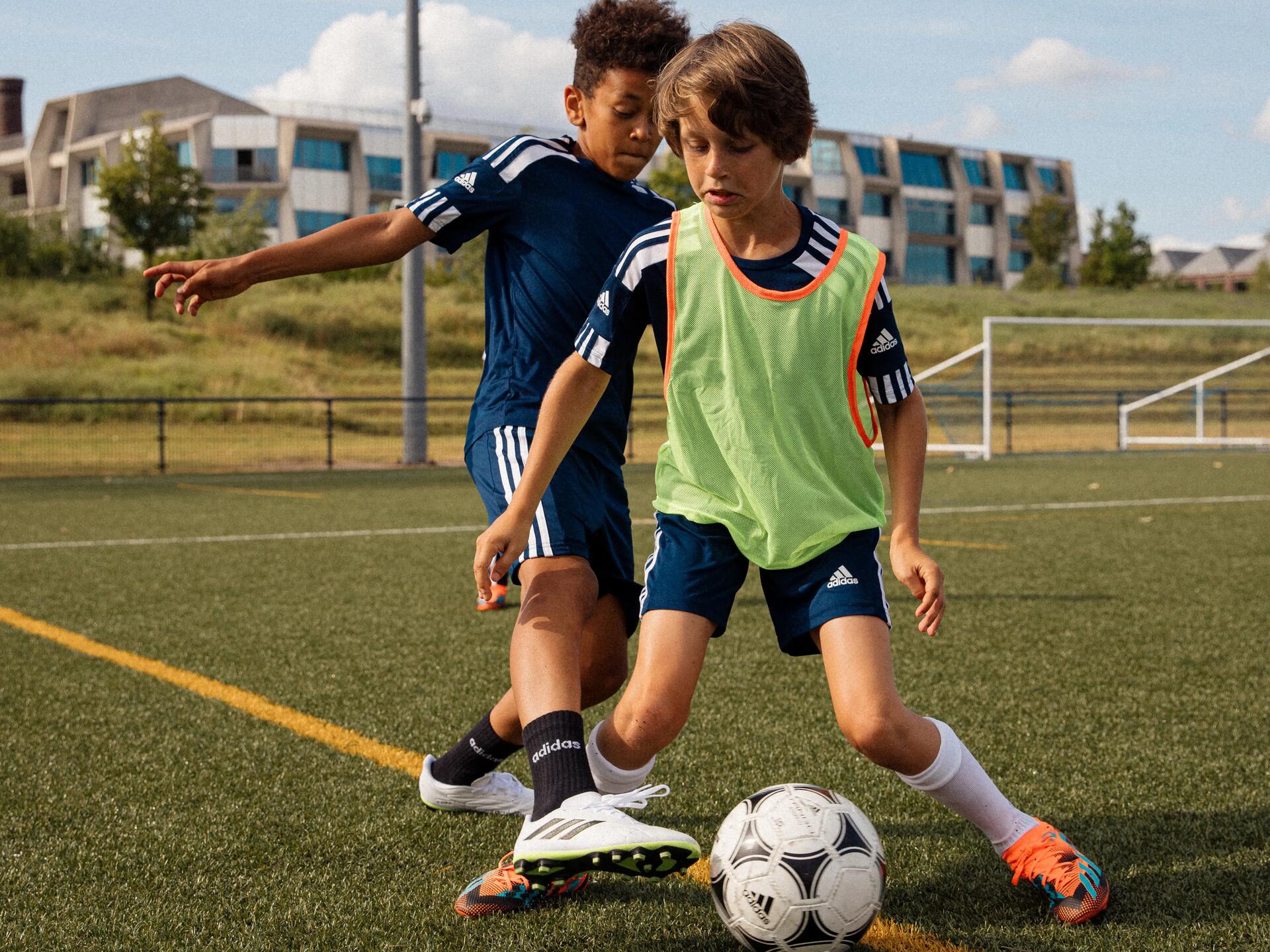 chłopcy grający w piłkę nożną ubrani w odzież piłkarską