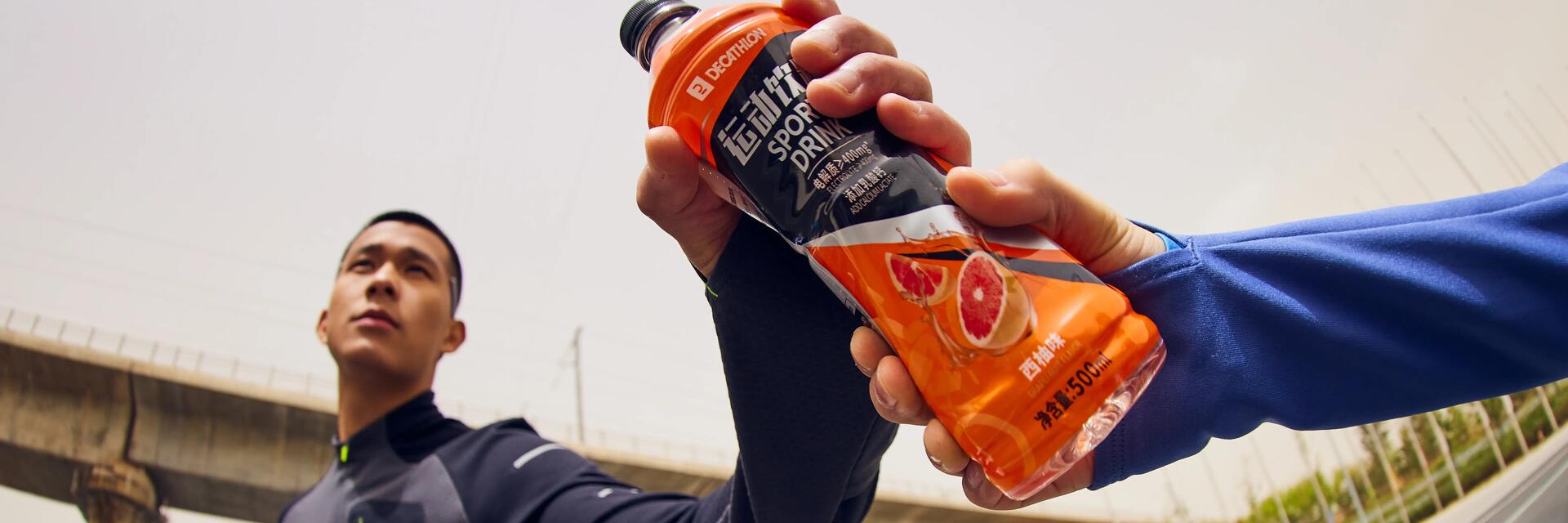Een man geeft een Decathlon sportdrank aan een andere man