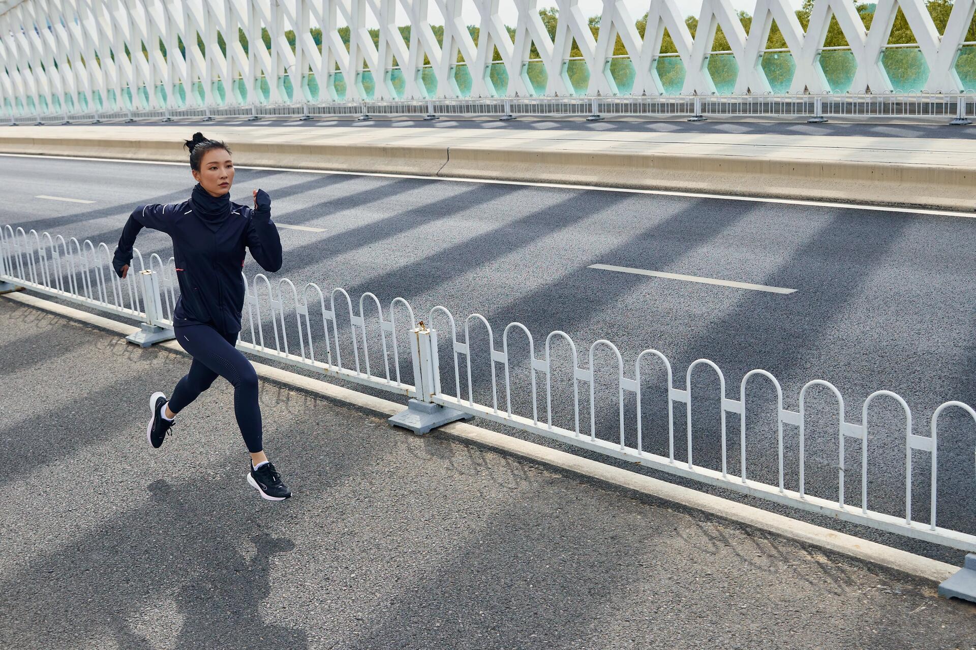 Kobieta w stroju sportowym trenująca bieganie po chodniku