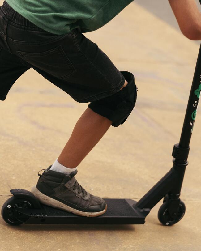 Stunt Scooter in schwarz; Kind mit Schoner auf dem Roller