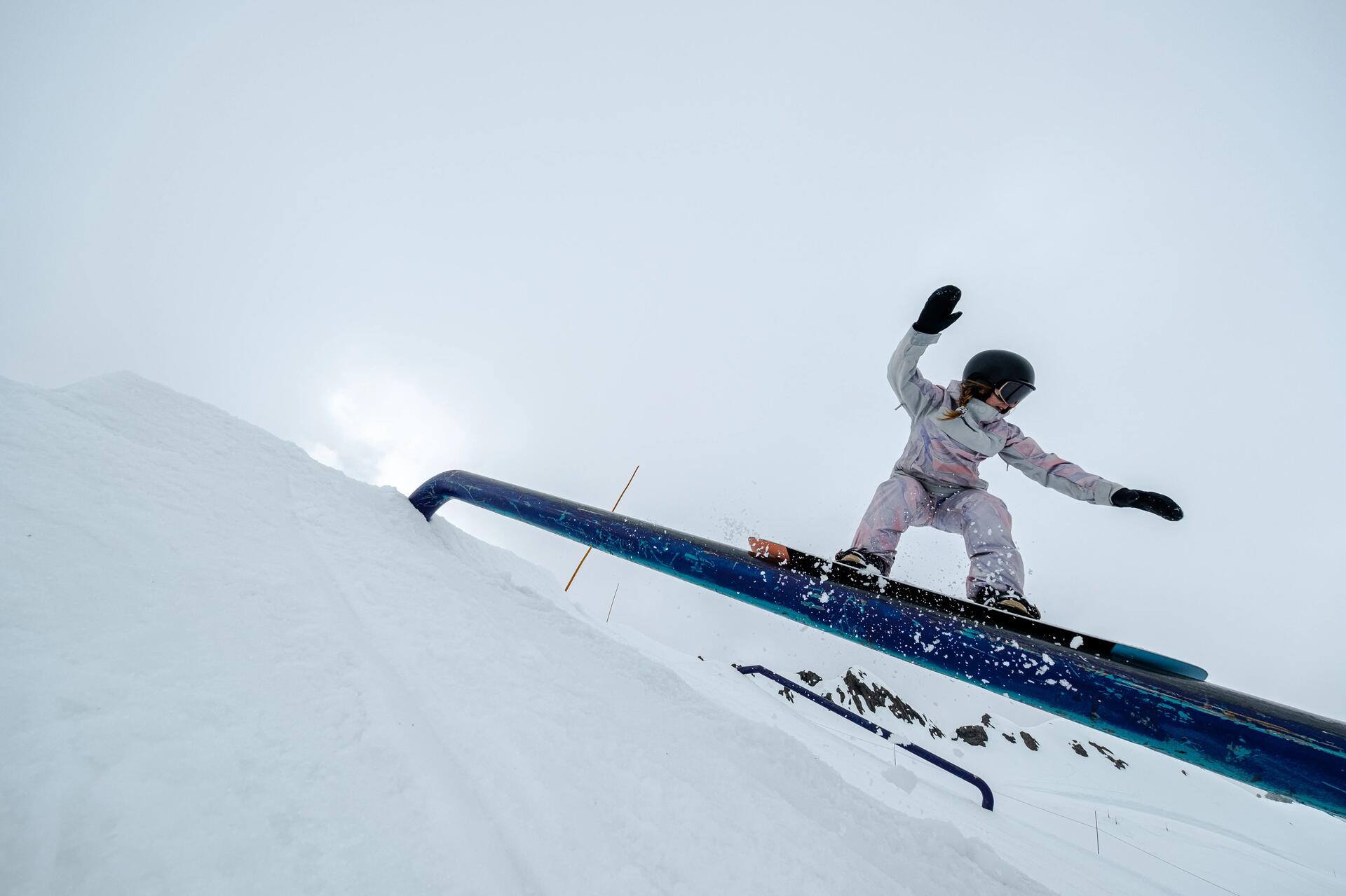 Kobieta trenująca snowboard freestyle w snowparku