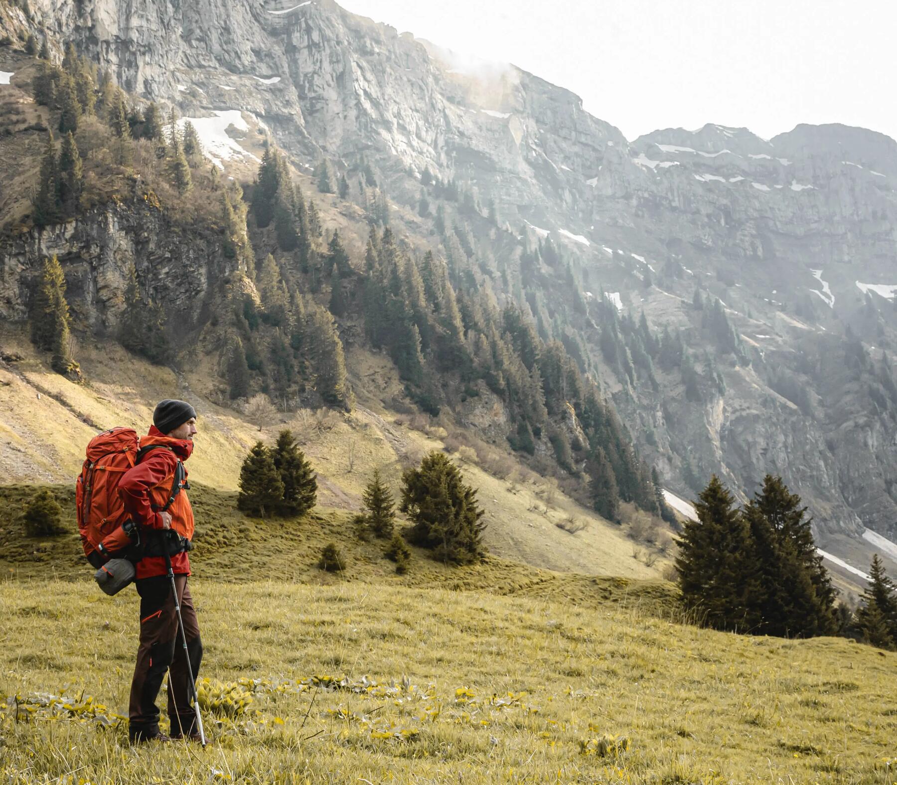 mężczyzna stojący w plenerze górskim z plecakiem turystycznym na plecach