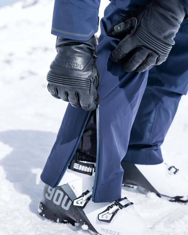 Mann öffnet Skihose am Fuß